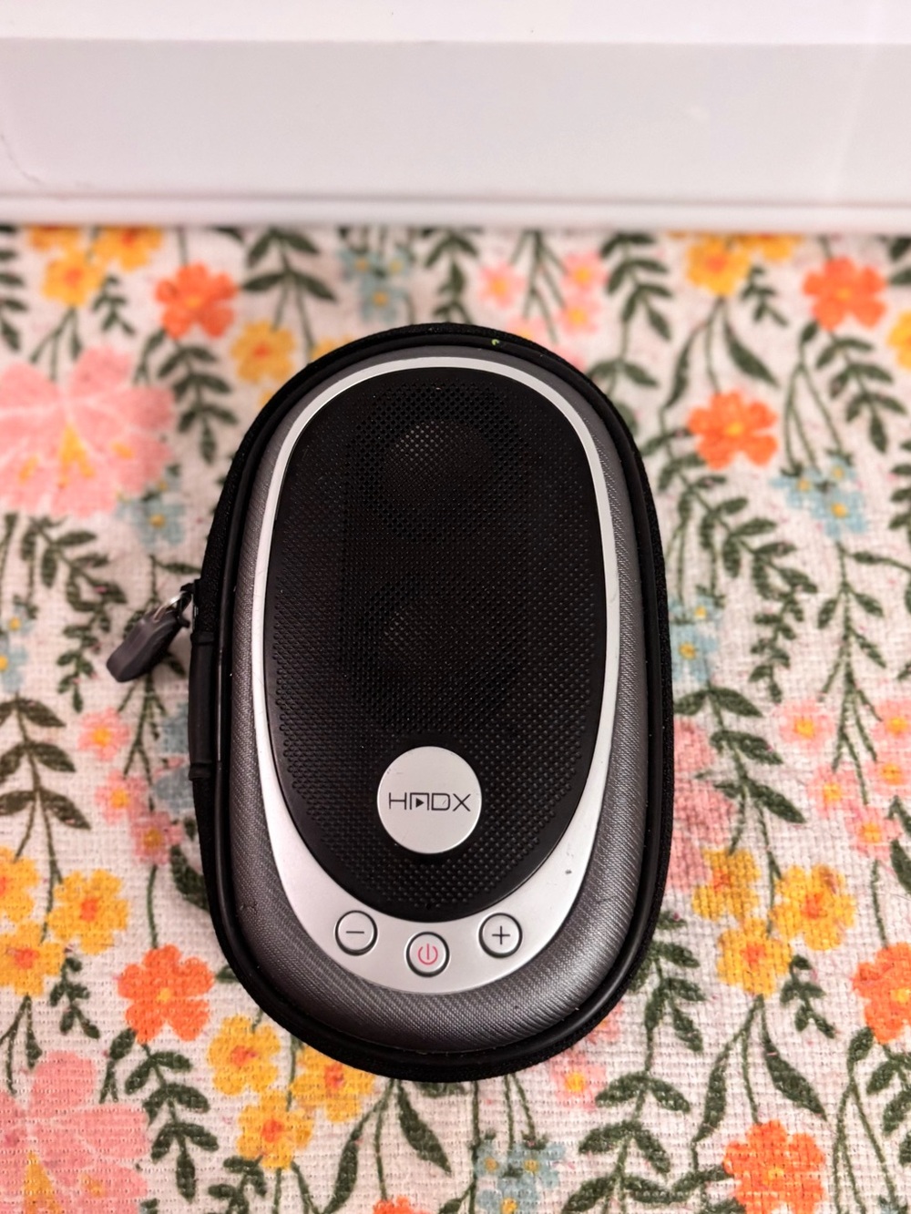 HMDX HX-G03 portable speaker featuring a black fabric grill and silver accents